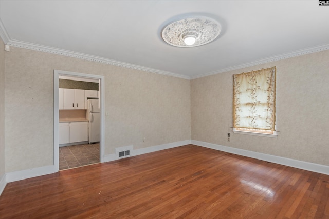 empty room with ornamental molding and hardwood / wood-style floors