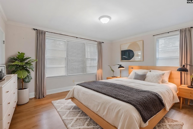 bedroom with ornamental molding and light hardwood / wood-style flooring