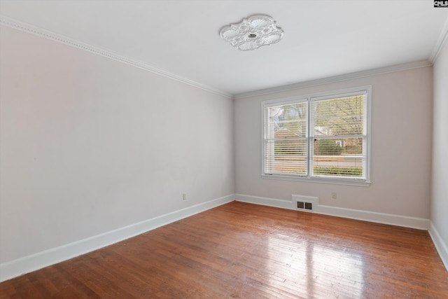 empty room featuring hardwood / wood-style floors and ornamental molding