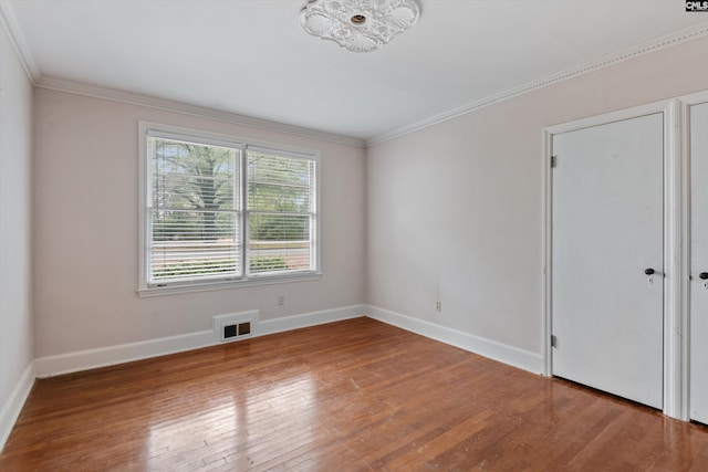 spare room with hardwood / wood-style flooring and ornamental molding