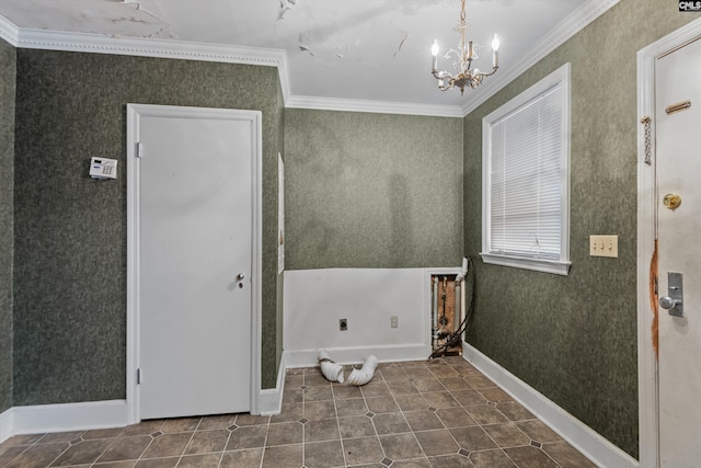 laundry room featuring dark tile patterned floors, ornamental molding, and a chandelier