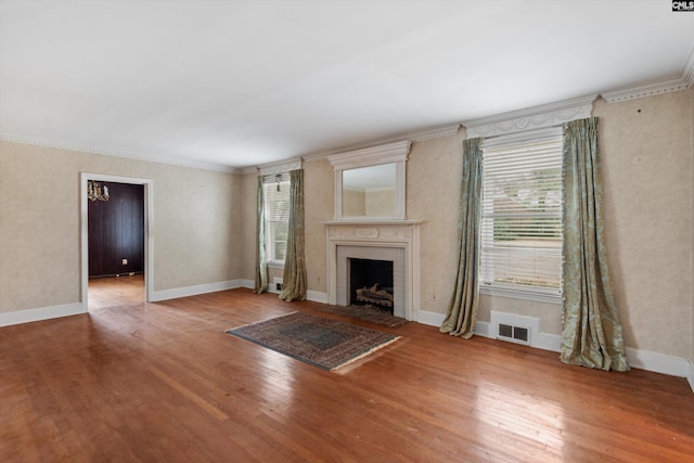 unfurnished living room featuring wood-type flooring and ornamental molding