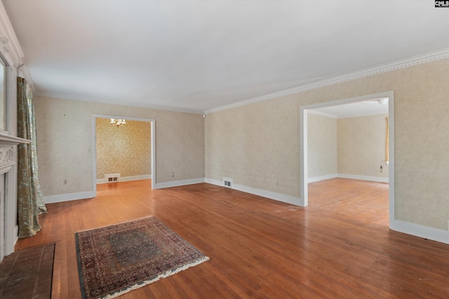 unfurnished living room with wood-type flooring, a notable chandelier, and crown molding