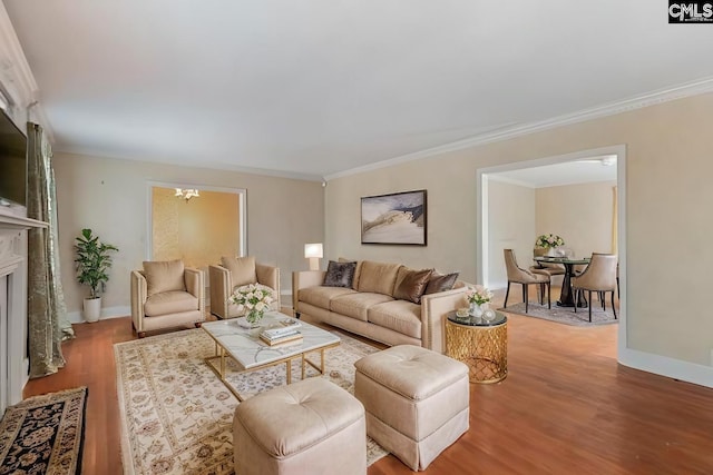 living room featuring hardwood / wood-style flooring, crown molding, and an inviting chandelier