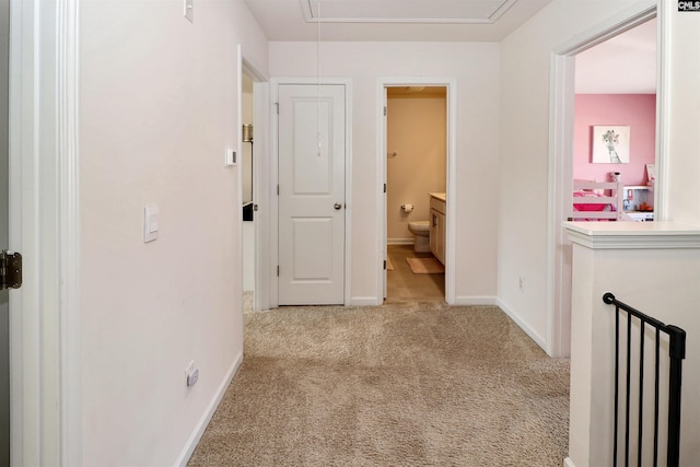 hallway featuring light colored carpet