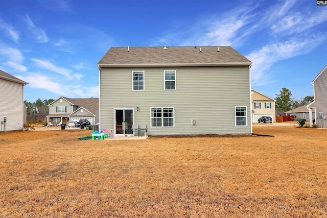 rear view of property featuring a yard and a patio area