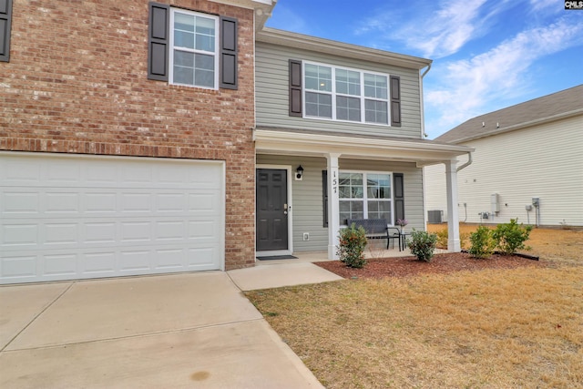 view of front of house featuring a porch, a garage, and a front yard