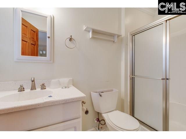 bathroom featuring vanity, toilet, and walk in shower