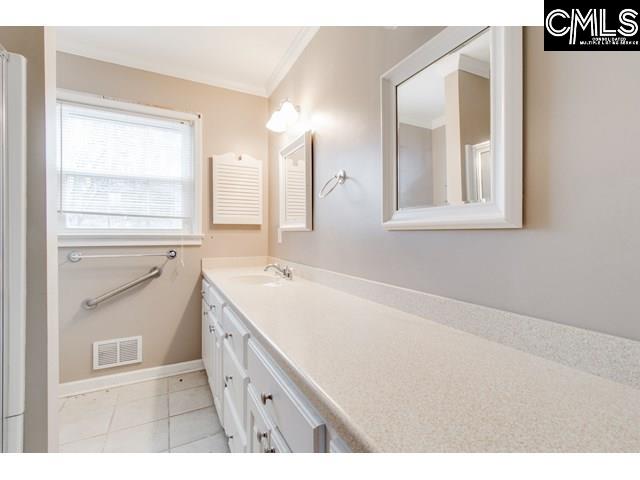 bathroom with tile patterned flooring, vanity, and ornamental molding