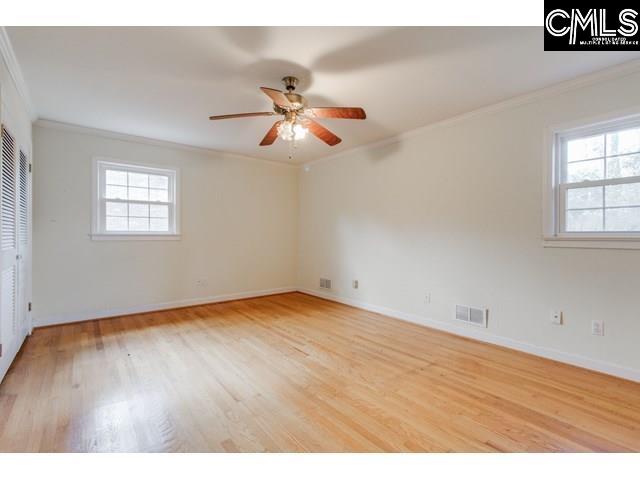 unfurnished room featuring ornamental molding, plenty of natural light, and hardwood / wood-style floors