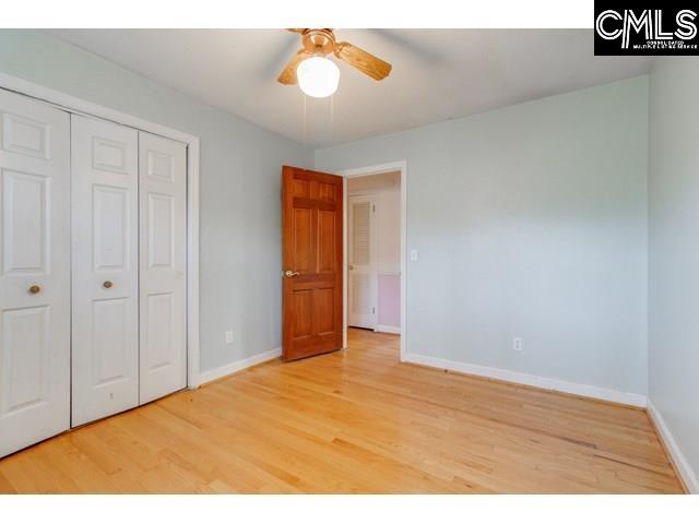 unfurnished bedroom with ceiling fan, light hardwood / wood-style floors, and a closet