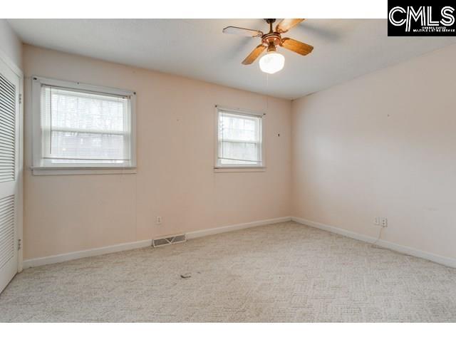 carpeted empty room featuring ceiling fan