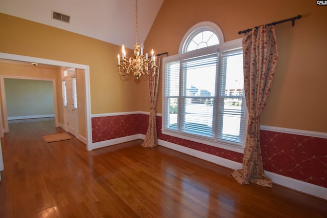 unfurnished room with wood-type flooring, a chandelier, and vaulted ceiling