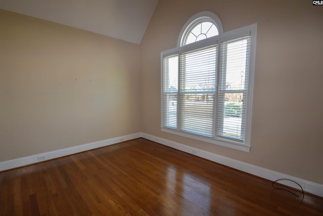 unfurnished room with hardwood / wood-style flooring and vaulted ceiling