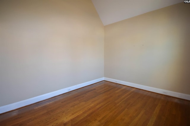 empty room with hardwood / wood-style flooring and lofted ceiling