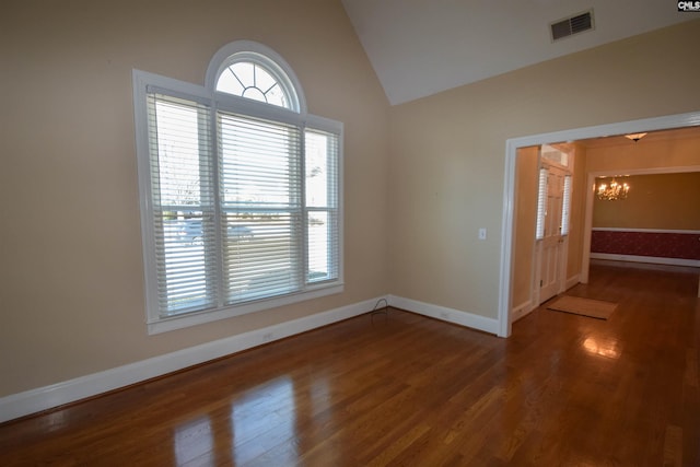 unfurnished room with lofted ceiling, wood-type flooring, and a chandelier