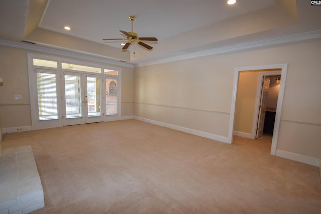 spare room featuring crown molding, light colored carpet, and a tray ceiling