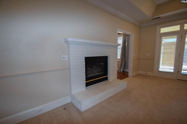 unfurnished living room featuring crown molding, a brick fireplace, plenty of natural light, and light carpet