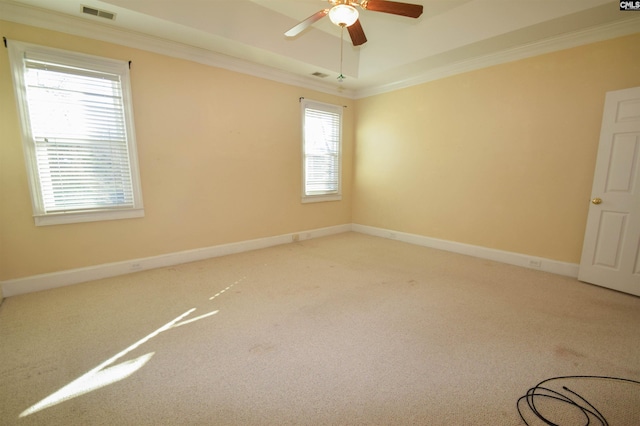 carpeted spare room featuring crown molding, ceiling fan, and a tray ceiling