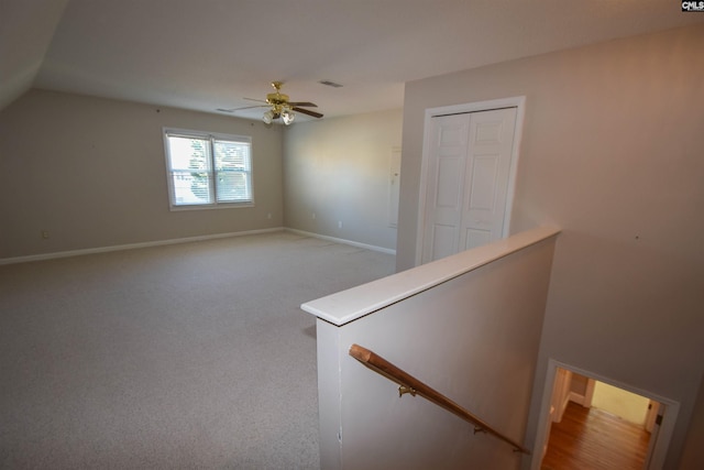 additional living space featuring lofted ceiling, light colored carpet, and ceiling fan