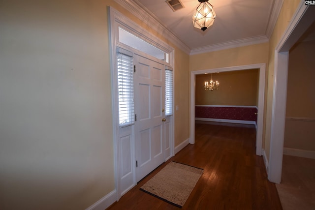 entrance foyer with an inviting chandelier, ornamental molding, and dark hardwood / wood-style floors