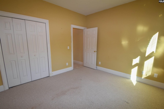 unfurnished bedroom with a closet and light carpet