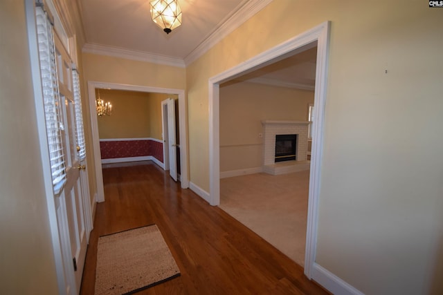 hallway with crown molding, hardwood / wood-style floors, and a chandelier