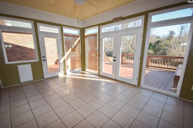 unfurnished sunroom featuring ceiling fan