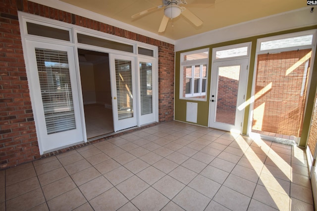 unfurnished sunroom with ceiling fan