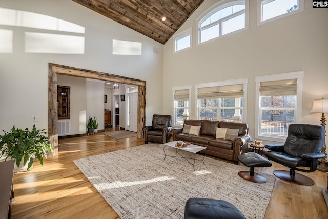 living room featuring high vaulted ceiling, visible vents, and wood finished floors