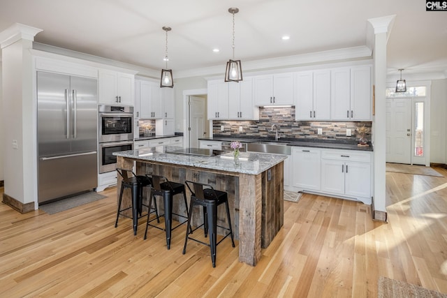 kitchen with ornamental molding, stainless steel appliances, and backsplash