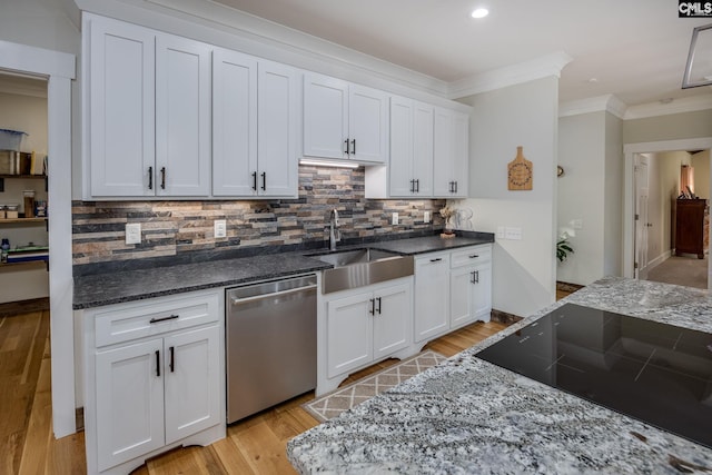 kitchen featuring a sink, dark stone countertops, ornamental molding, and dishwasher