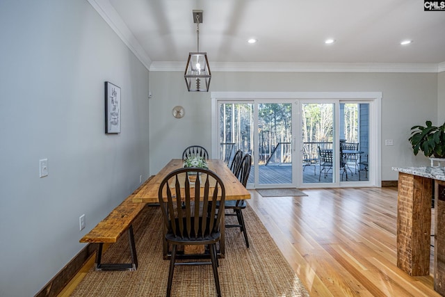 dining space with ornamental molding, recessed lighting, light wood-style flooring, and baseboards