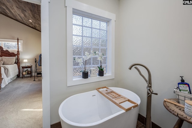 ensuite bathroom with vaulted ceiling, a soaking tub, and connected bathroom