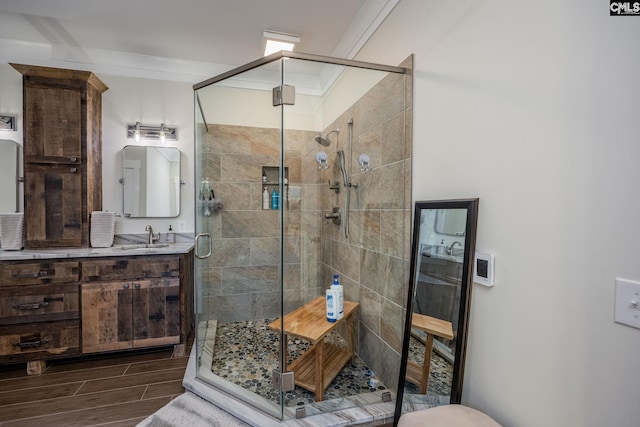 full bath featuring wood finish floors, a stall shower, and crown molding