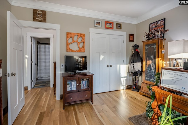 foyer entrance with ornamental molding and wood finished floors