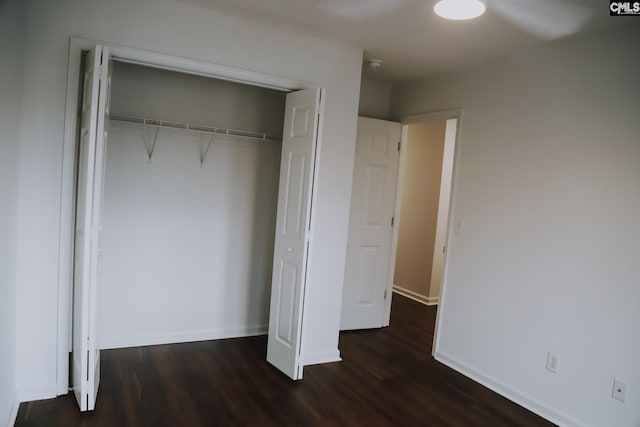 unfurnished bedroom featuring dark wood-type flooring and a closet