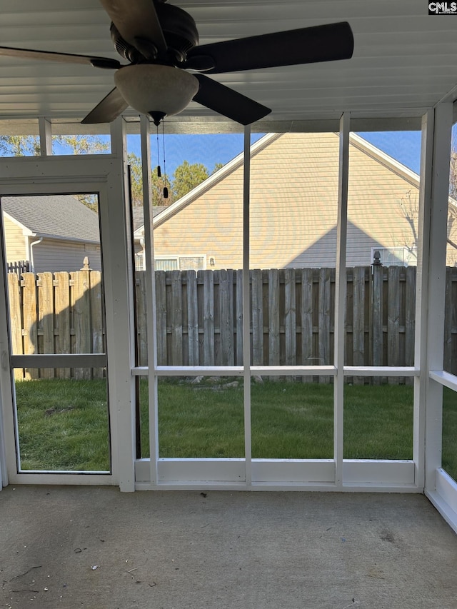 unfurnished sunroom featuring ceiling fan