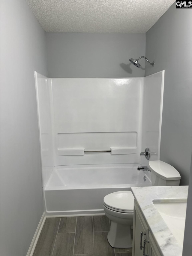 full bathroom with vanity, a textured ceiling, shower / tub combination, and toilet