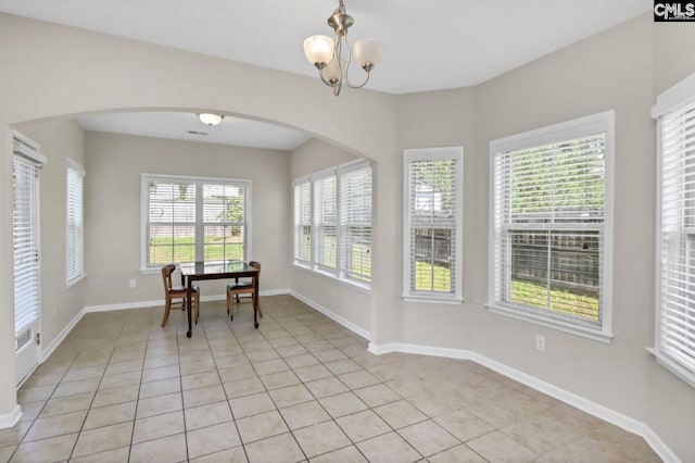 tiled dining room with a chandelier