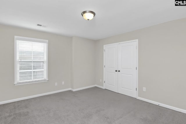 unfurnished bedroom with carpet floors and a closet