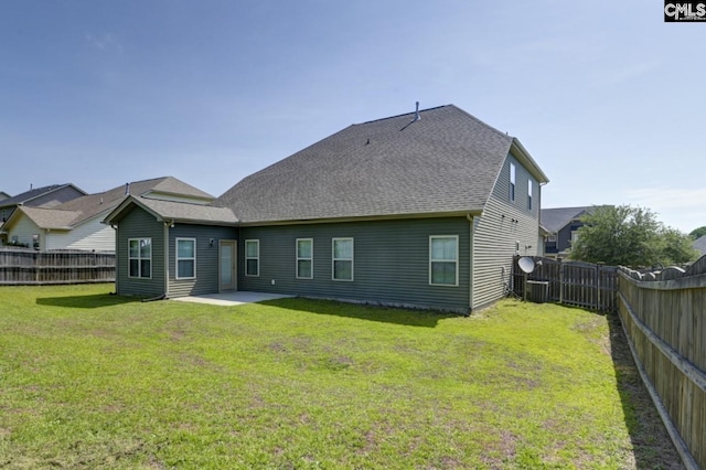 rear view of property featuring a lawn and a patio area