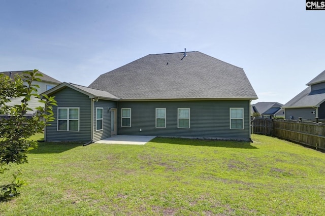 rear view of house featuring a yard and a patio