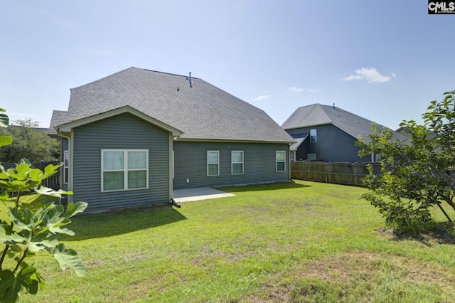 rear view of property featuring a lawn and a patio