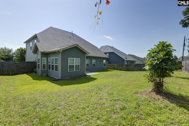 rear view of house featuring a lawn