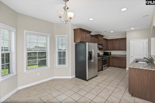 kitchen with sink, light tile patterned floors, appliances with stainless steel finishes, pendant lighting, and light stone countertops