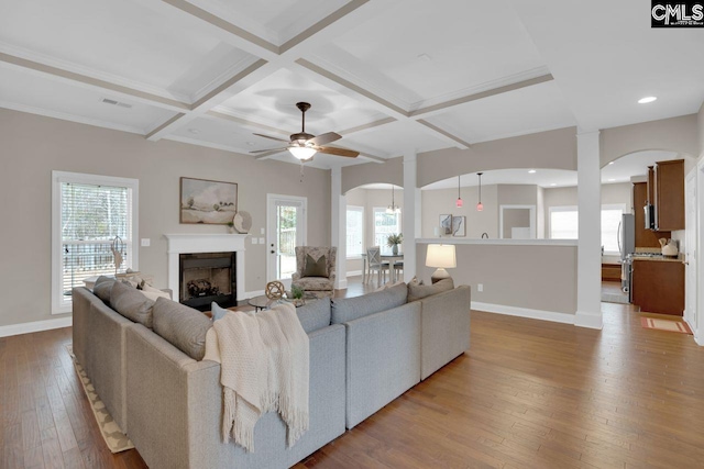 living room featuring beamed ceiling, a healthy amount of sunlight, coffered ceiling, and hardwood / wood-style floors