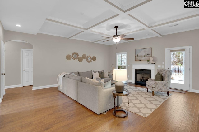 living room with beamed ceiling, coffered ceiling, ceiling fan, and light hardwood / wood-style flooring