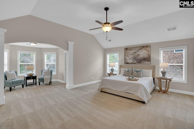 carpeted bedroom featuring lofted ceiling, decorative columns, and ceiling fan