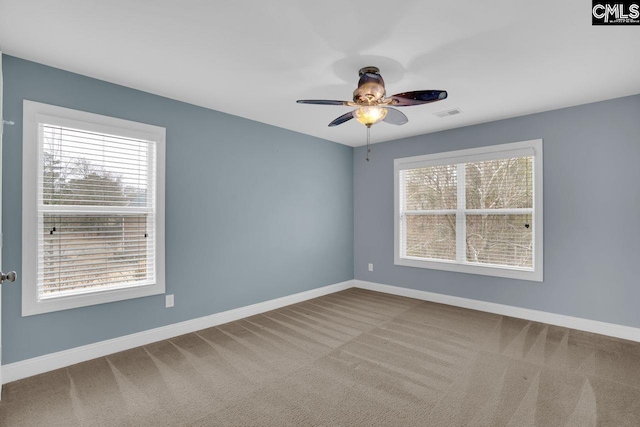 spare room with ceiling fan, carpet flooring, and a wealth of natural light